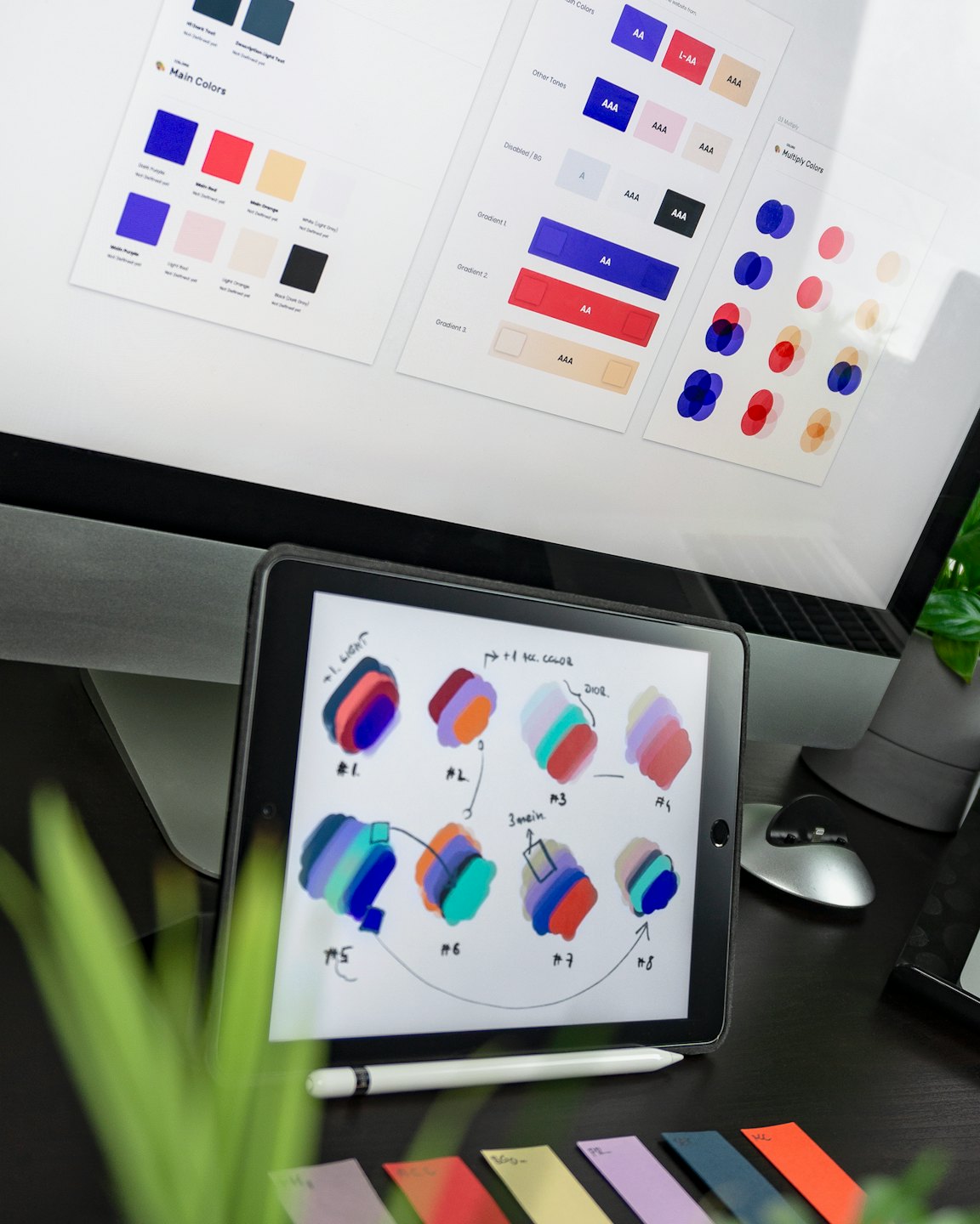 Monitor komputera i tablet pokazujące pracę projektową i próbki kolorów.